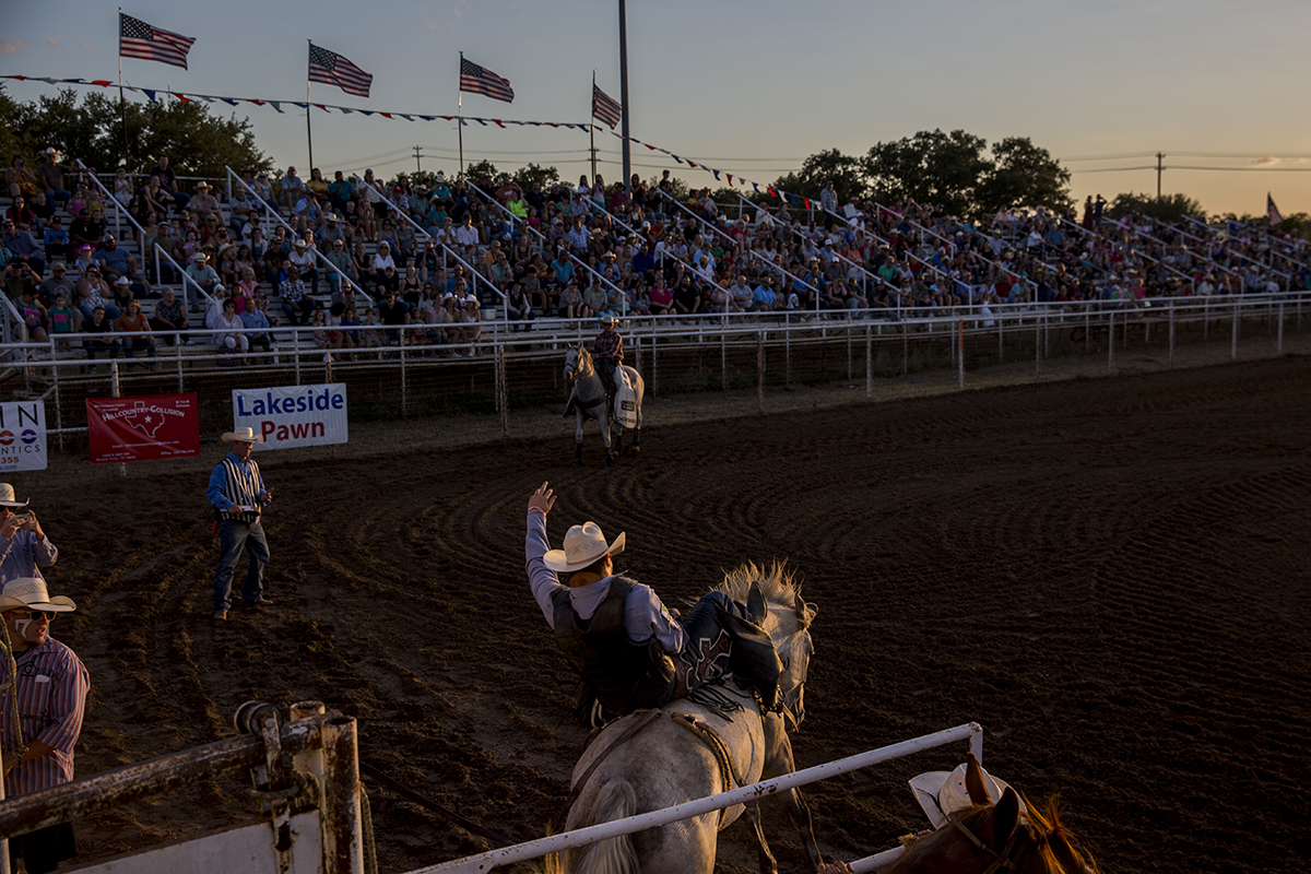 A crowd watches bareback bronc riding during the Marble Falls Rodeo.
