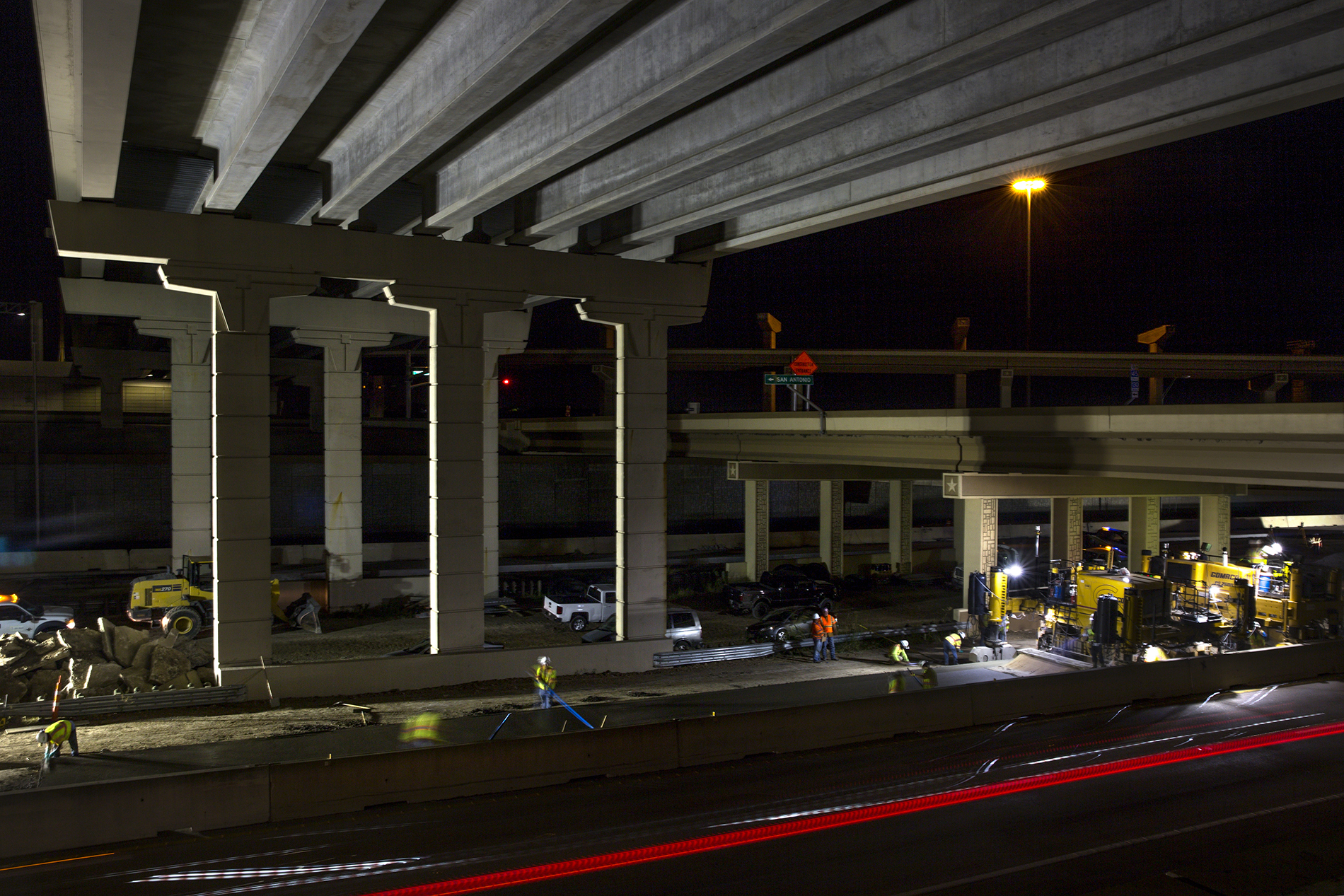Construction crew members smooth out concrete on Interstate 130 northbound under the Manor Expressway toll road and Highway 290 near Austin.