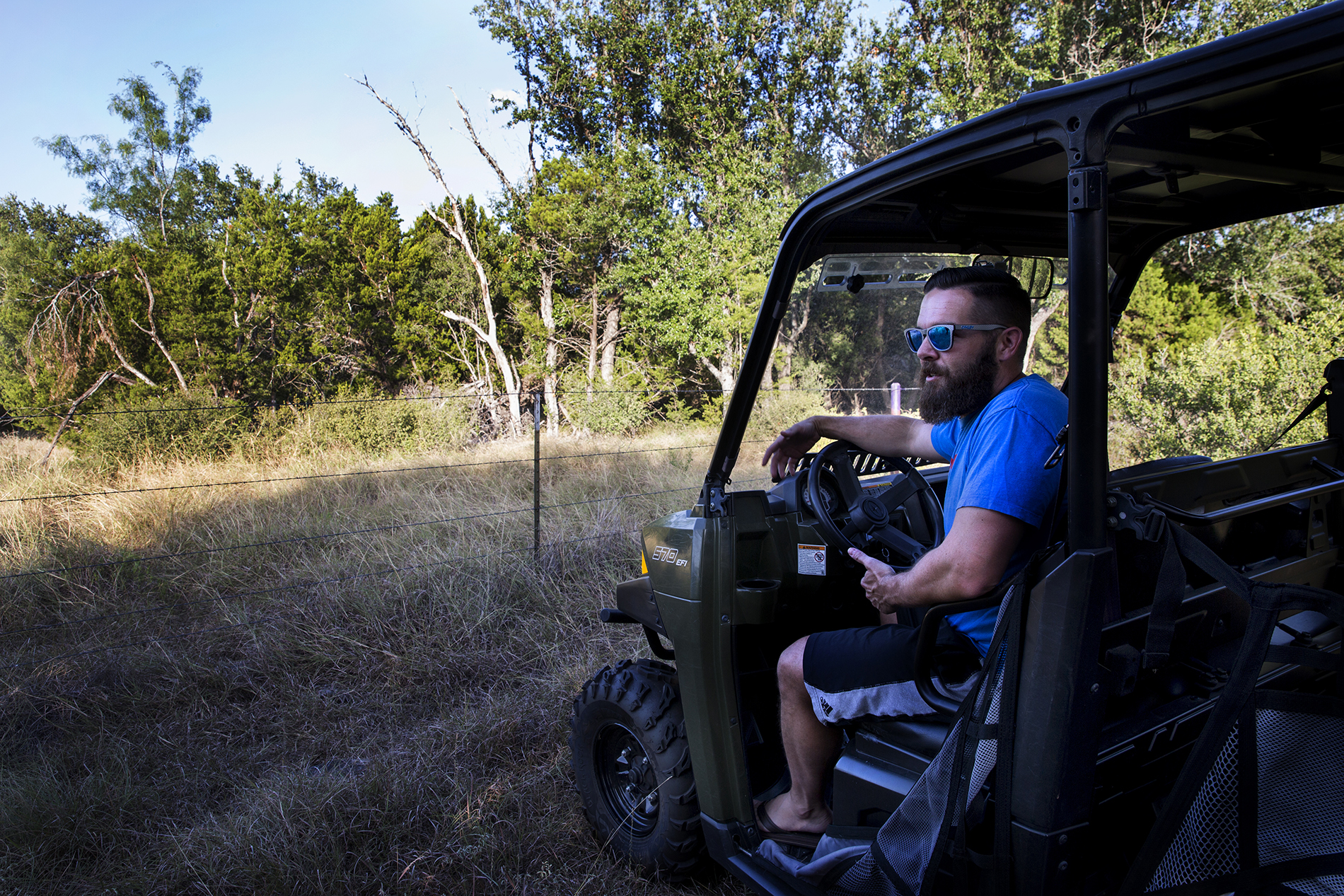 Double Horn resident Jason Welch, a gastrointestinal doctor, rides up to the fence line with a four-wheeler on his property near his home in Double Horn.