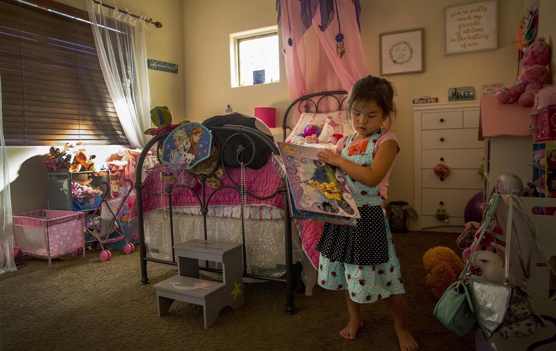 Haley Welch, 4, reads a book in her bedroom.