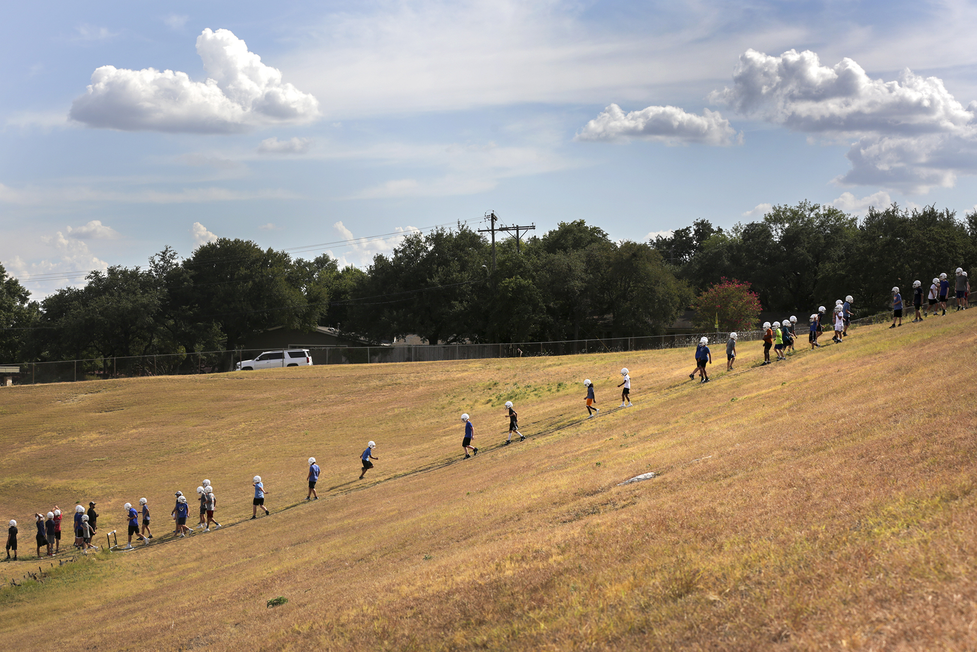 Players on the Murchison Matadors football team run down a hill during practice near the football field at Murchison Middle School off of Far West Boulevard.