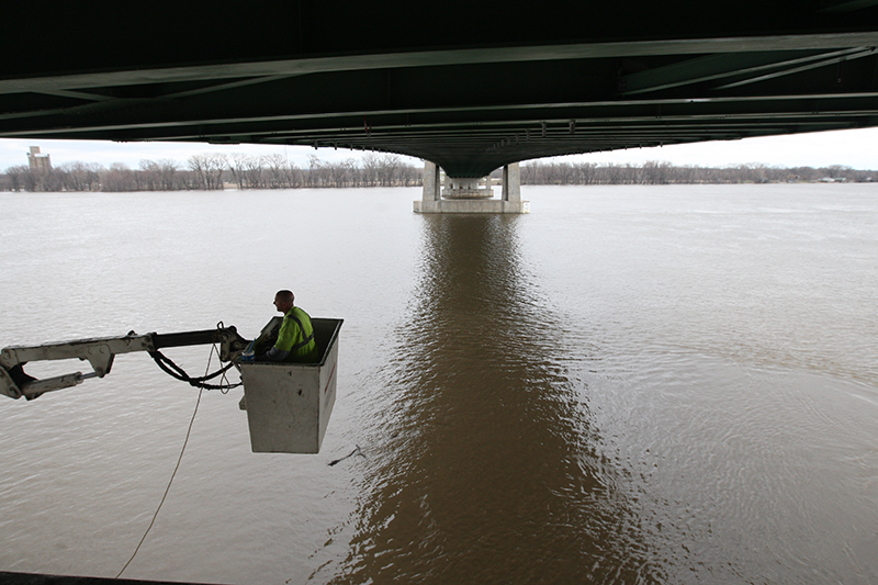 Brian Cosgrove of McClain & Co. out of Waterloo works from a bucket truck over the Mississippi River inspecting the underside of the Great River Bridge April 12, 2013 in Burlington. [Brenna Norman/thehawkeye.com]