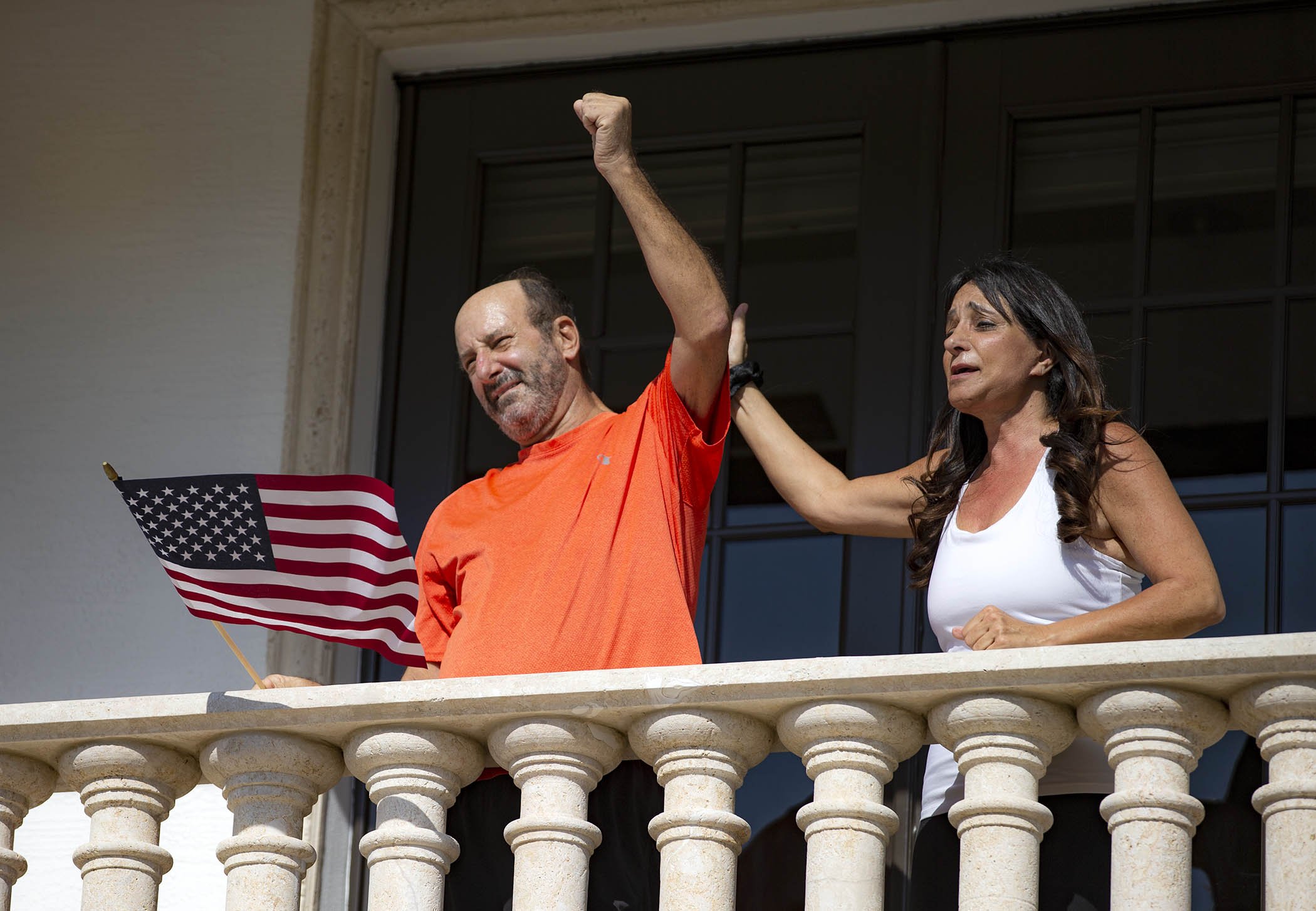 Alan Levy and his wife, Lynne, wave to a parade of friends and neighbors passing their Boca Raton home April 21, 2020, welcoming Alan home after his hospitalization with COVID-19. Levy and his son, Josh, had unsuccessfully tried to get tested by their local health departments when they felt they had coronavirus in early March.