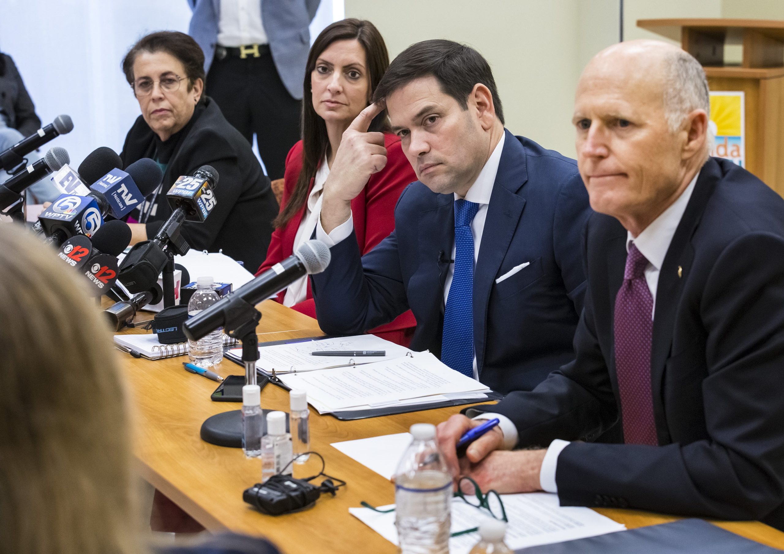 U.S. Sen. Rick Scott, right, speaks with U.S. Sen. Marco Rubio and health officials on March 6, 2020, at the Palm Beach County Health Department in West Palm Beach. As governor, Scott oversaw massive cuts in the state's health department.